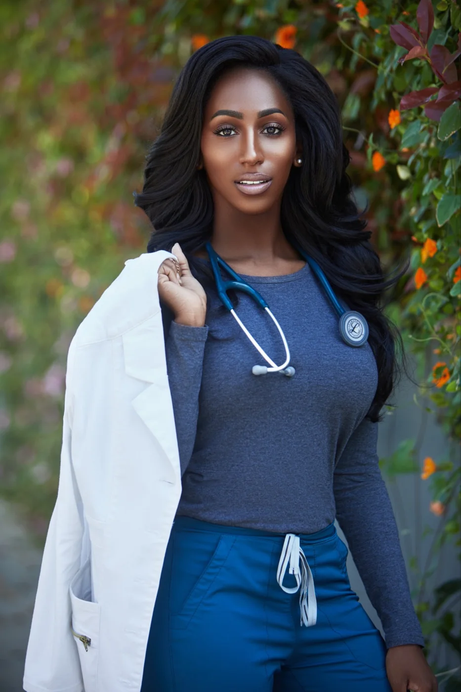 Dr. Lightning outdoors holding her white coat over her shoulder